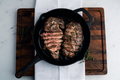 Cooked ribeye steaks in a cast-iron skillet